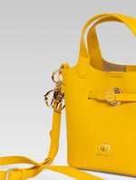 Load image into Gallery viewer, Side view of delphine bucket bag in yellow color with shoulder strap
