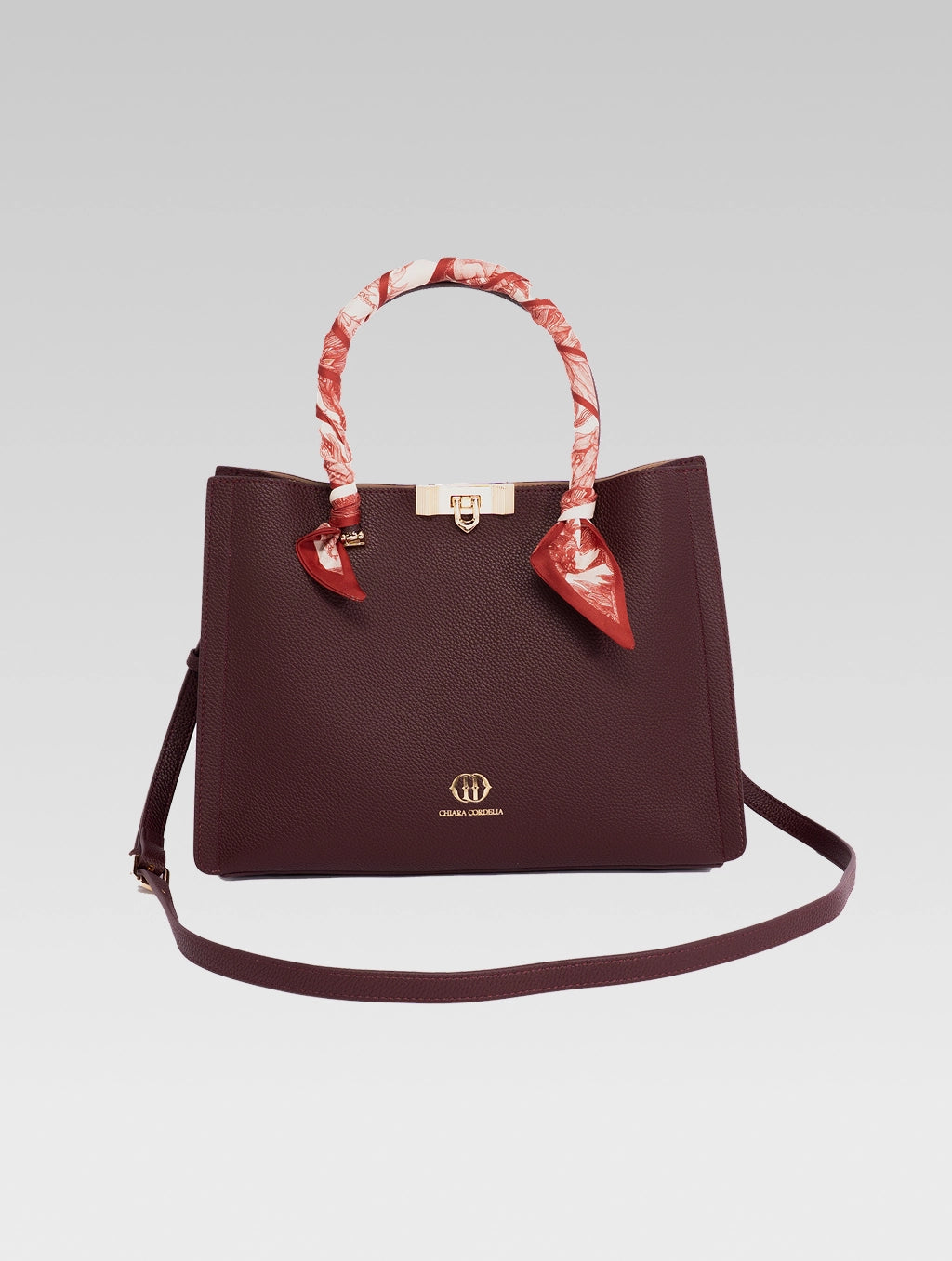 Front view of Alessia Tote bag in Wine Red color with shoulder strap and a red and white clothe beaded to it's handle and 