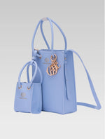 Load image into Gallery viewer, Side view of genevieve bucket bag in baby blue color and a mini tote bag
