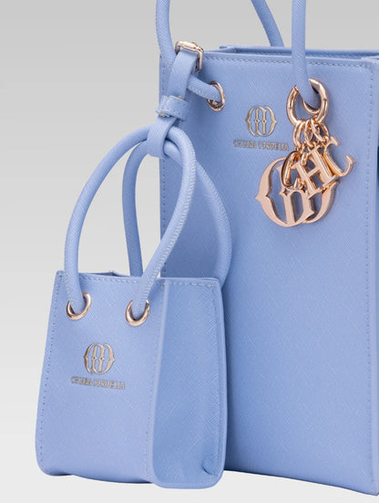 Cropped side view of genevieve bucket bag in baby blue color and a mini tote bag