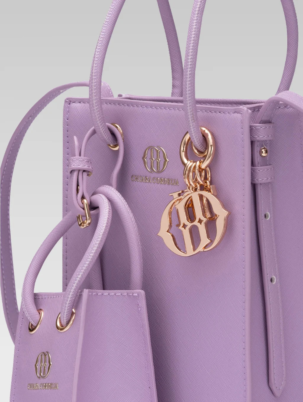 Cropped side view of Genevieve Bucket bag in lavender color and a mini tote bag