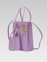Load image into Gallery viewer, Side view of Genevieve Bucket bag in lavender color and a mini tote bag
