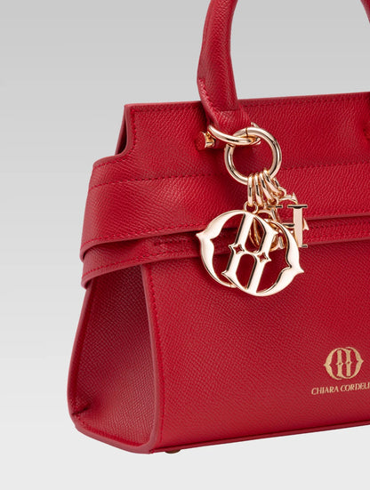 Side closeup view of ophelia envelope bag handle in red color