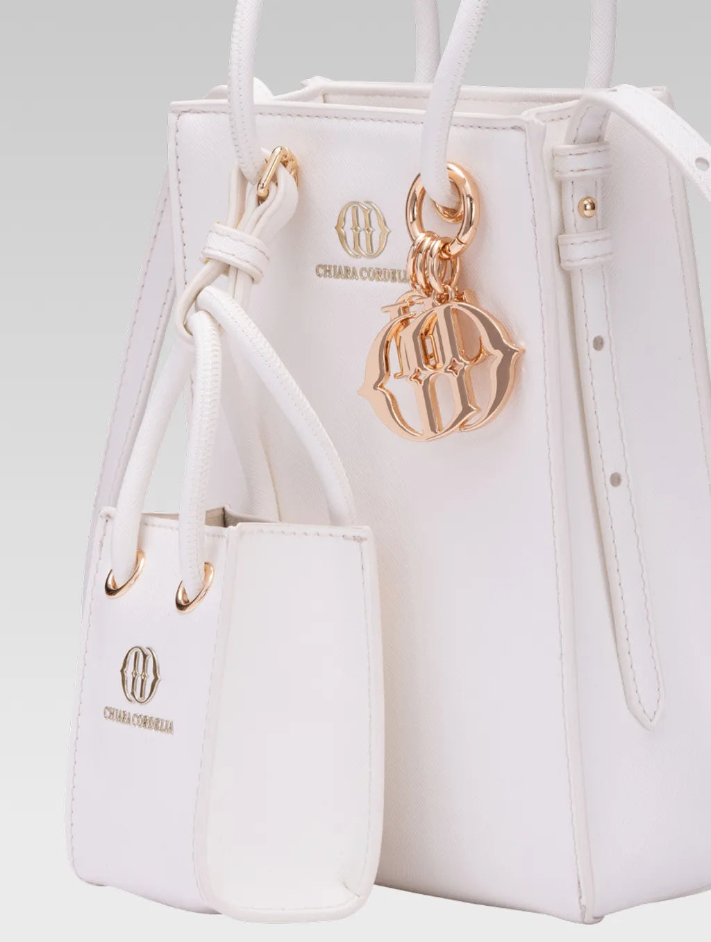 Cropped side view of Genevieve Bucket bag in white color and a mini tote bag